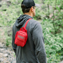 Load image into Gallery viewer, Person wearing a red backpack with 'MERED' branding in a natural setting